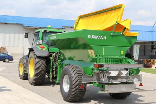 KURIER Düngerstreuer mit gelber Abdeckplane am Traktor, Heckansicht mit Zweischeibenstreuwerk